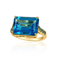 Stunning Swiss Blue Topaz ring, it’s geometric form makes an enchanting piece of fine jewelry to wear for every occasion.  Emerald Cut Swiss Blue Topaz: 7.9 ct Round Swiss Blue Topaz: 0.3 ct 14K Yellow Gold: 3.23 grams