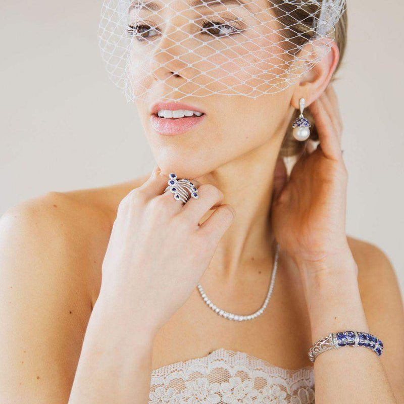 This pair of earrings are perfect for special occasions, this design gives the piece a feminine touch.  Pearl, Blue Sapphire Cap & Diamonds Earrings